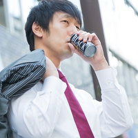 缶コーヒーを飲むサラリーマン、ビジネスシーンの写真