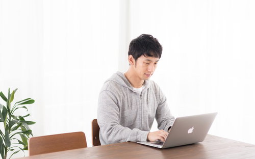 リビングで株価をチェックするデイトレーダー