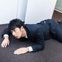 朝礼中ほふく前進で出社する遅刻常習者の写真