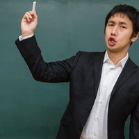 黒板の前でチョークを生徒に投げつける学級崩壊風の先生の写真