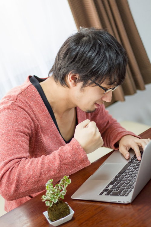 「なんてことだ」と拳を握るプログラマー