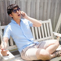すみませーん、体調悪くて休みます。サングラスをかけて電話する男性の写真