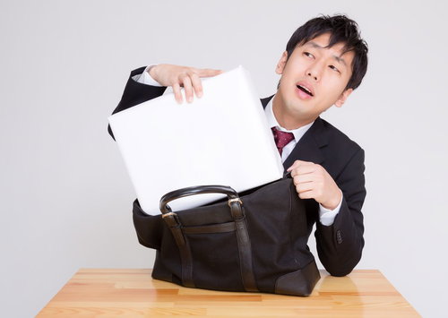 札束に見立てた箱がかばんに入らない男性