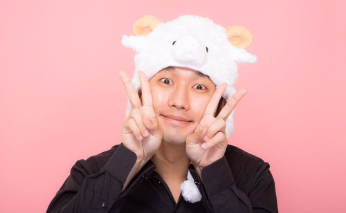新年を喜ぶ羊の帽子をかぶった男性