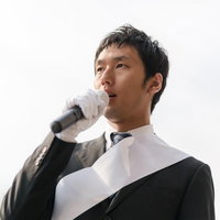 街宣車の上から演説する立候補者の写真