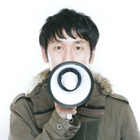 カーキ色モッズコートを着た拡声器を持つ男性スタッフによる案内の写真