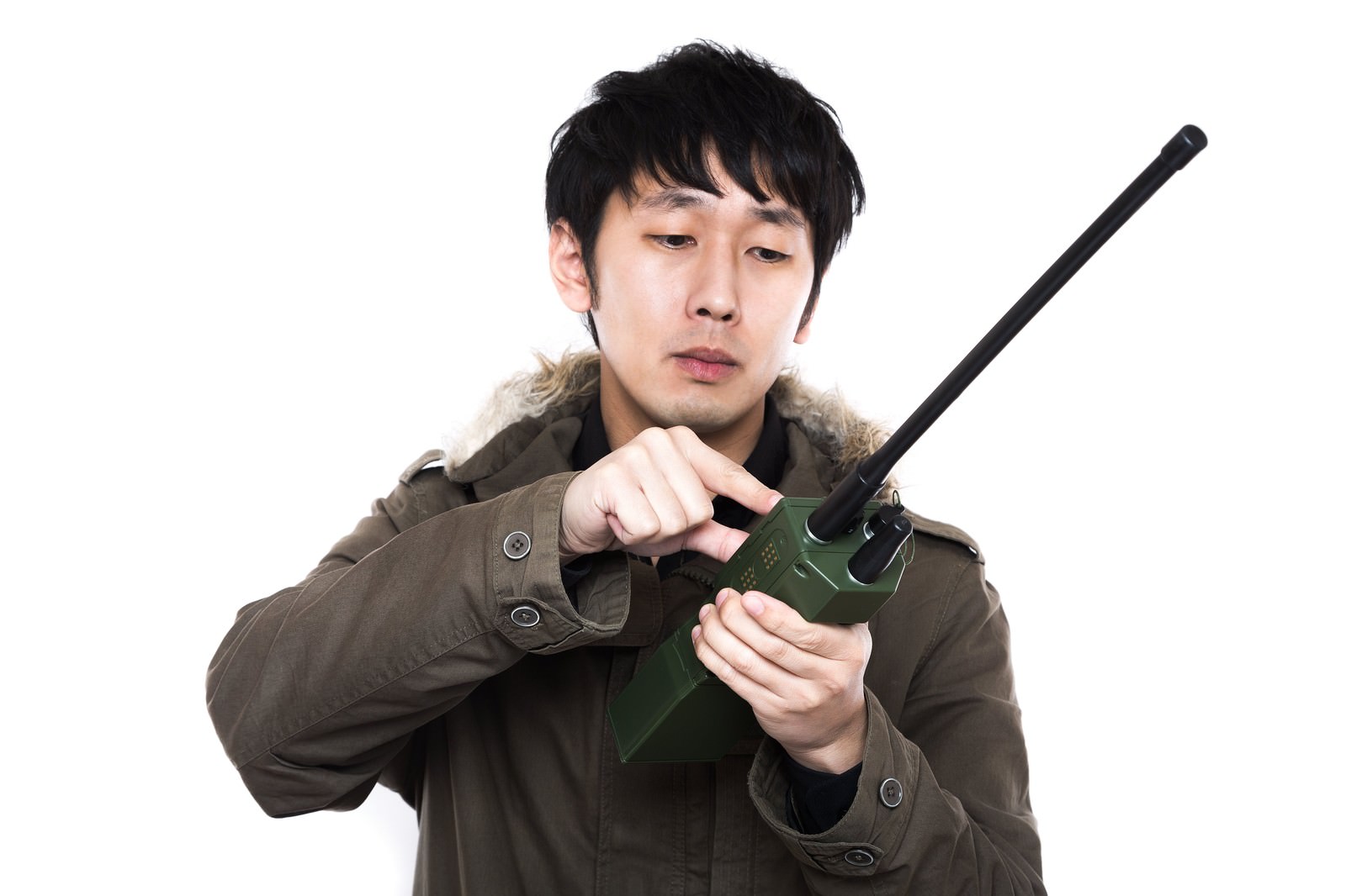 無線機を両手で持って操作する茶色のジャケットの男性［モデル：大川竜弥］