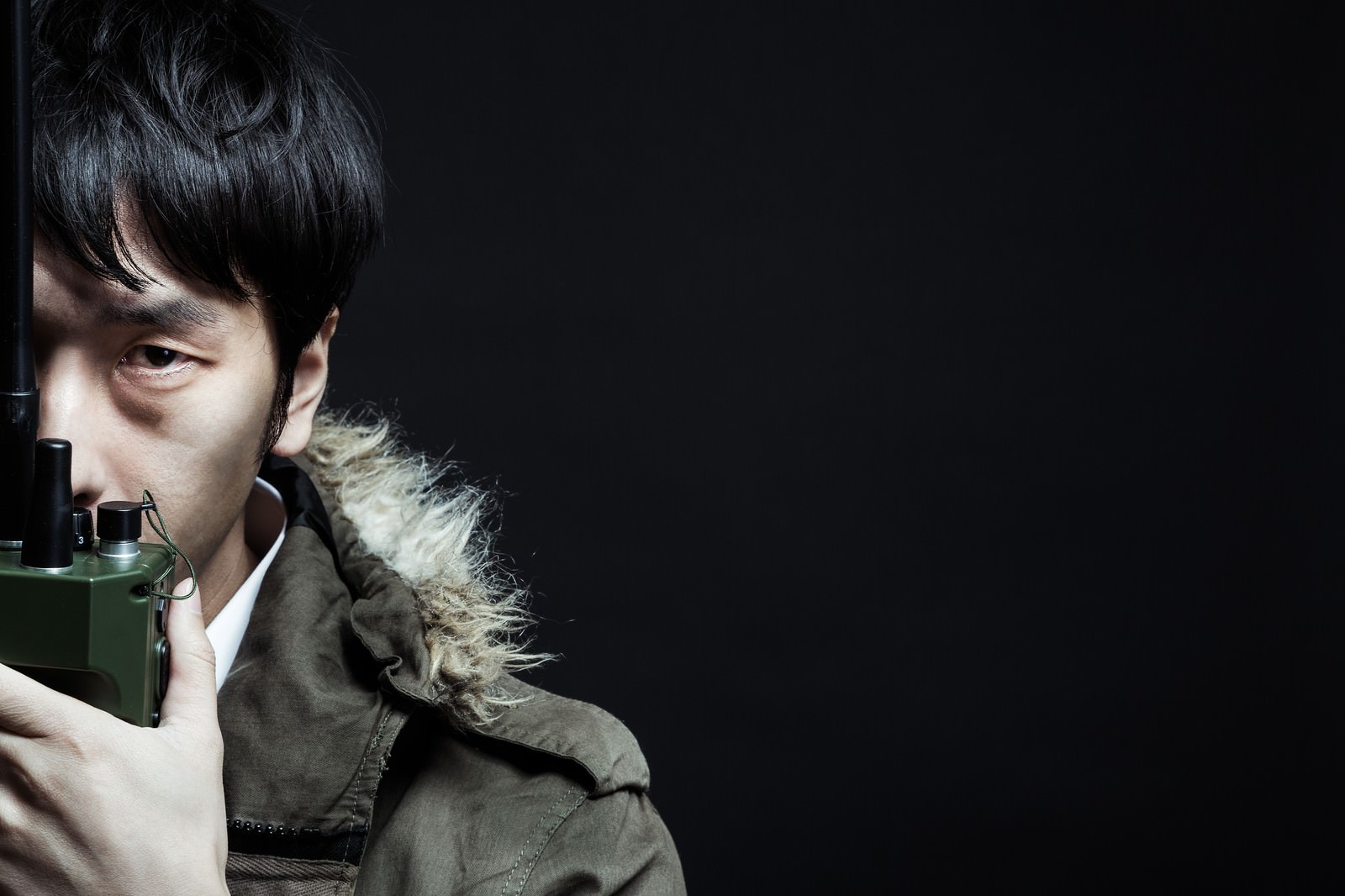 トランシーバーで連絡を取る刑事風男性［モデル：大川竜弥］