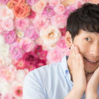 ピンクのバラに囲まれて笑顔を見せるデオコおじさんの写真