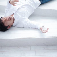 熱中症で倒れ込み苦しむ男性の脱水症状と意識障害の写真