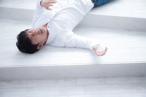 熱中症で倒れ込み苦しむ男性の脱水症状と意識障害