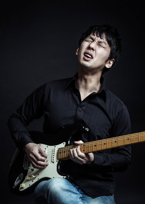 黒いオーダーメイドシャツを着てチョーキングするブルースギタリスト