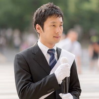 人ごみの中で書類を持つ選挙活動の男性の写真