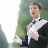 マニフェストを語り胸に手を当てる立候補者の写真