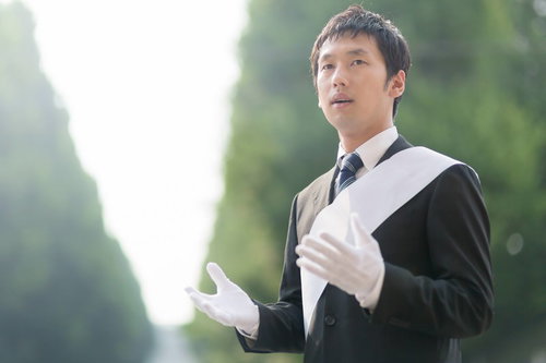 マニフェストを語り胸に手を当てる立候補者