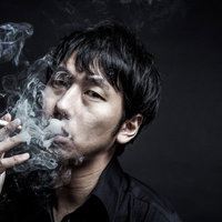 タバコを吸う男性の横顔、隠れ家で待ち構えるマフィアのボスの写真