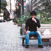 ベンチで一人ランチをとる男性の写真