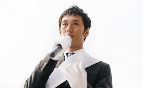 街宣車の上から見上げる立候補者