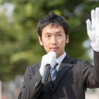 手を振りクリーンなイメージをPRする政治家の写真