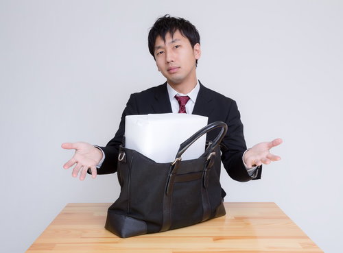 札束に見立てた箱がかばんに入らない男性