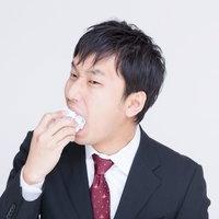 こんなゴミ企画は食ってやる！プレゼン資料を口に入れはじめる男性の写真