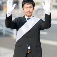 両手を挙げて支援を呼びかける党公認候補の写真