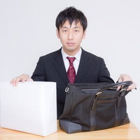 借用した現金とそれを運んだかばんを用意する男性の写真