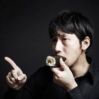 今年の方角を確認しながら恵方巻を頬張る福男の写真