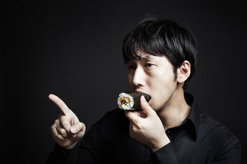 今年の方角を確認しながら恵方巻を頬張る福男