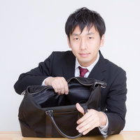 かばんの中身を見せるサラリーマンの写真