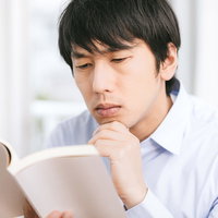 参考書を読みながら考え込むエンジニアの写真