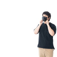 今日も花粉が多いなぁと黒マスクを調整する男性の写真