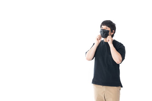 今日も花粉が多いなぁと黒マスクを調整する男性