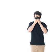 黒マスクをした匿名の男性が両手でマスクを押さえるポーズの写真