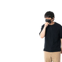黒マスクをしながら咳をする男性の写真