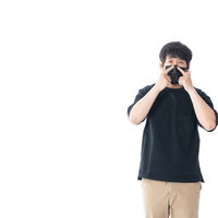 黒マスクの鼻の部分を調整する男性の写真