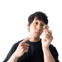 1BTCのゴールドコインを指差す男性の投資の写真