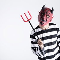 ハロウィンの悪魔コスプレ男性がピッチフォークを持つの写真