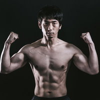 肉体美をアピールする細マッチョ男性の力こぶの写真