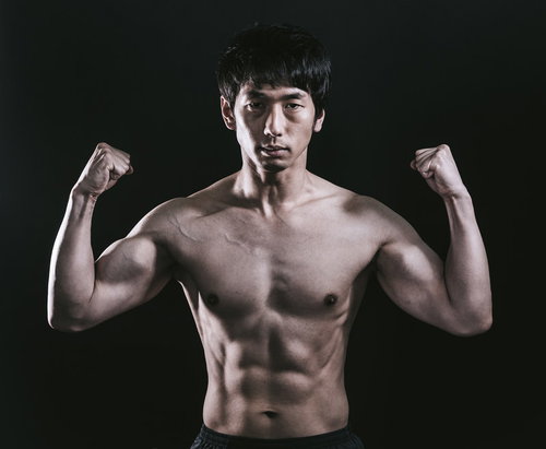 肉体美をアピールする細マッチョ男性の力こぶ