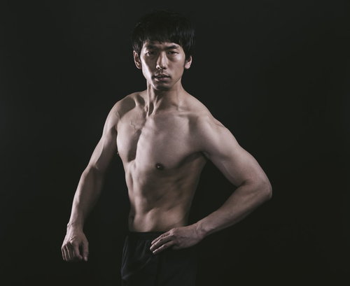 振り返る度にポーズを決める上裸の筋肉質な男性