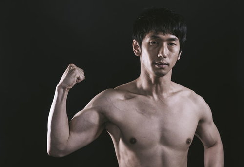 カッチカチに鍛え上げた上腕二頭筋をアピールする男性