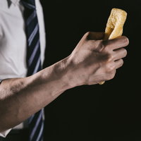 油揚げを握りしめる男性の腕の写真