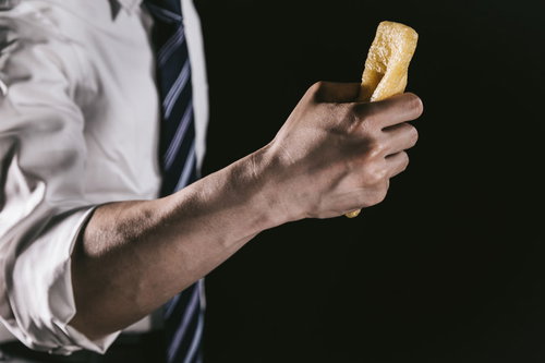 油揚げを握りしめる男性の腕