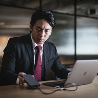 誰もいない深夜のオフィスで裏帳簿のデータを抜き取る社員の写真