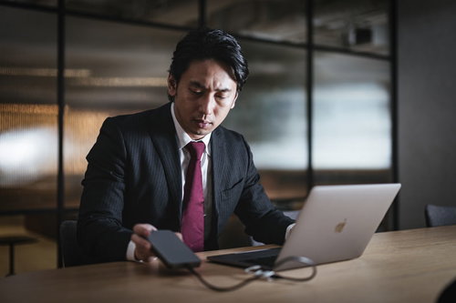 誰もいない深夜のオフィスで裏帳簿のデータを抜き取る社員