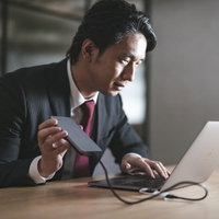 （もう少しでコピー完了っと・・・）データを持ち出すスーツの男の写真