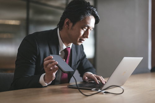 （もう少しでコピー完了っと・・・）データを持ち出すスーツの男