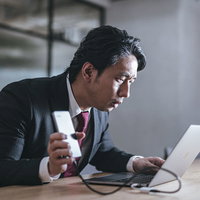サポート詐欺のポップアップに慌てるビジネスマンの写真