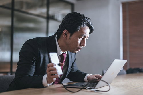 サポート詐欺のポップアップに慌てるビジネスマン